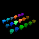Charged strontium aluminate glow iin the dark acrylic paint in 18 jars arranged in neat rows, glowing under UV/blacklight