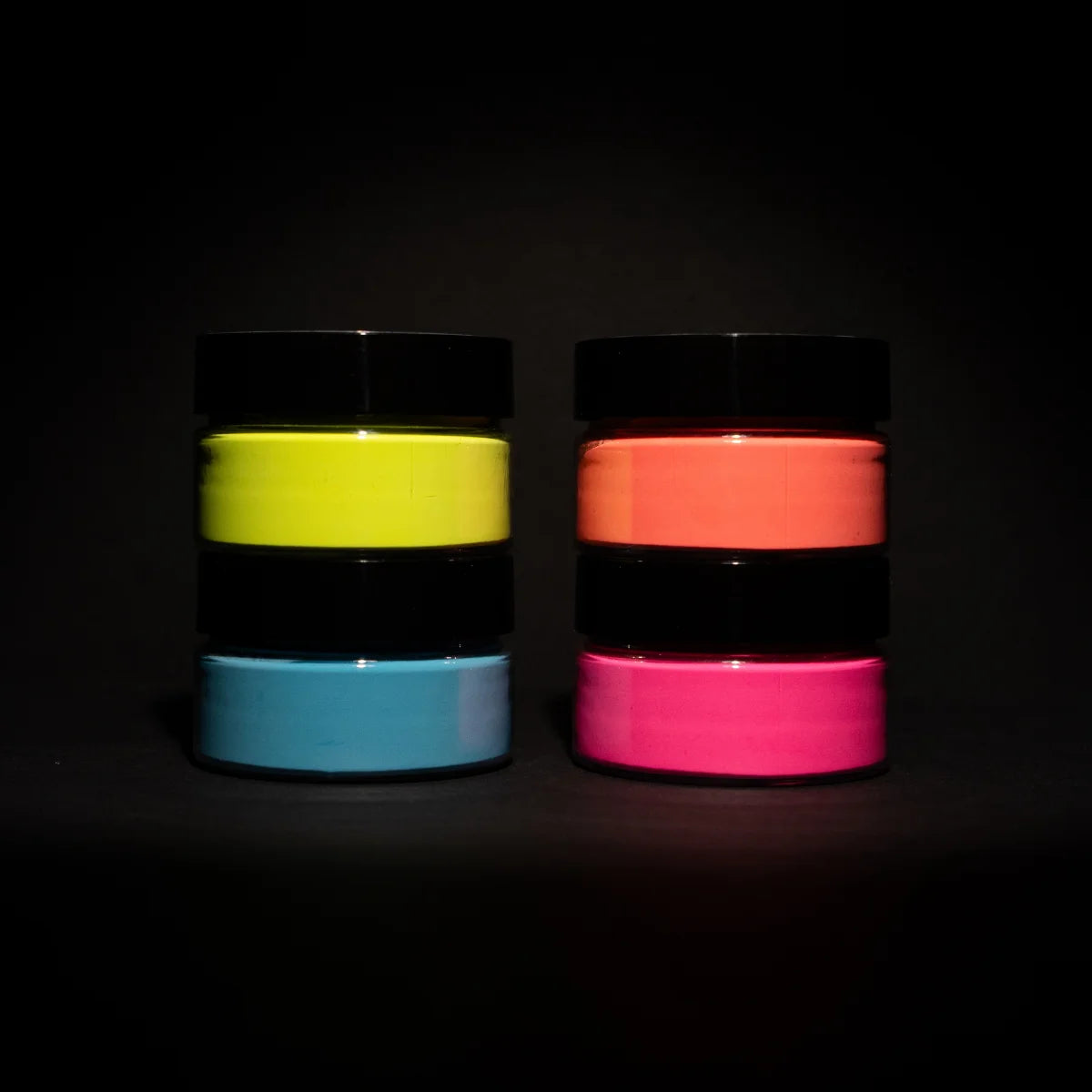 Dark-room shot of a four-jar glow-in-the-dark paint pyramid—showcasing the brightest, long-lasting luminescence for night-time DIY