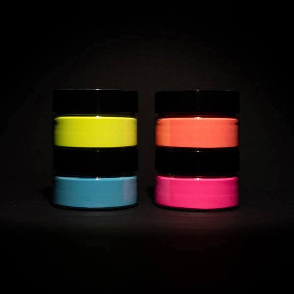 Dark-room shot of a four-jar glow-in-the-dark paint pyramid—showcasing the brightest, long-lasting luminescence for night-time DIY