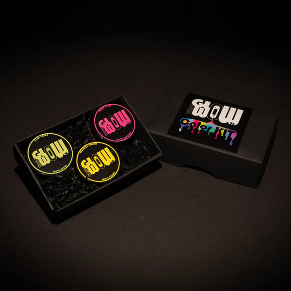 Overhead view of a premium 3-color neon acrylic glow paint kit in a sleek black tray—featuring vibrant yellow, hot pink, and lime green jars for long-lasting, best-in-class luminescence