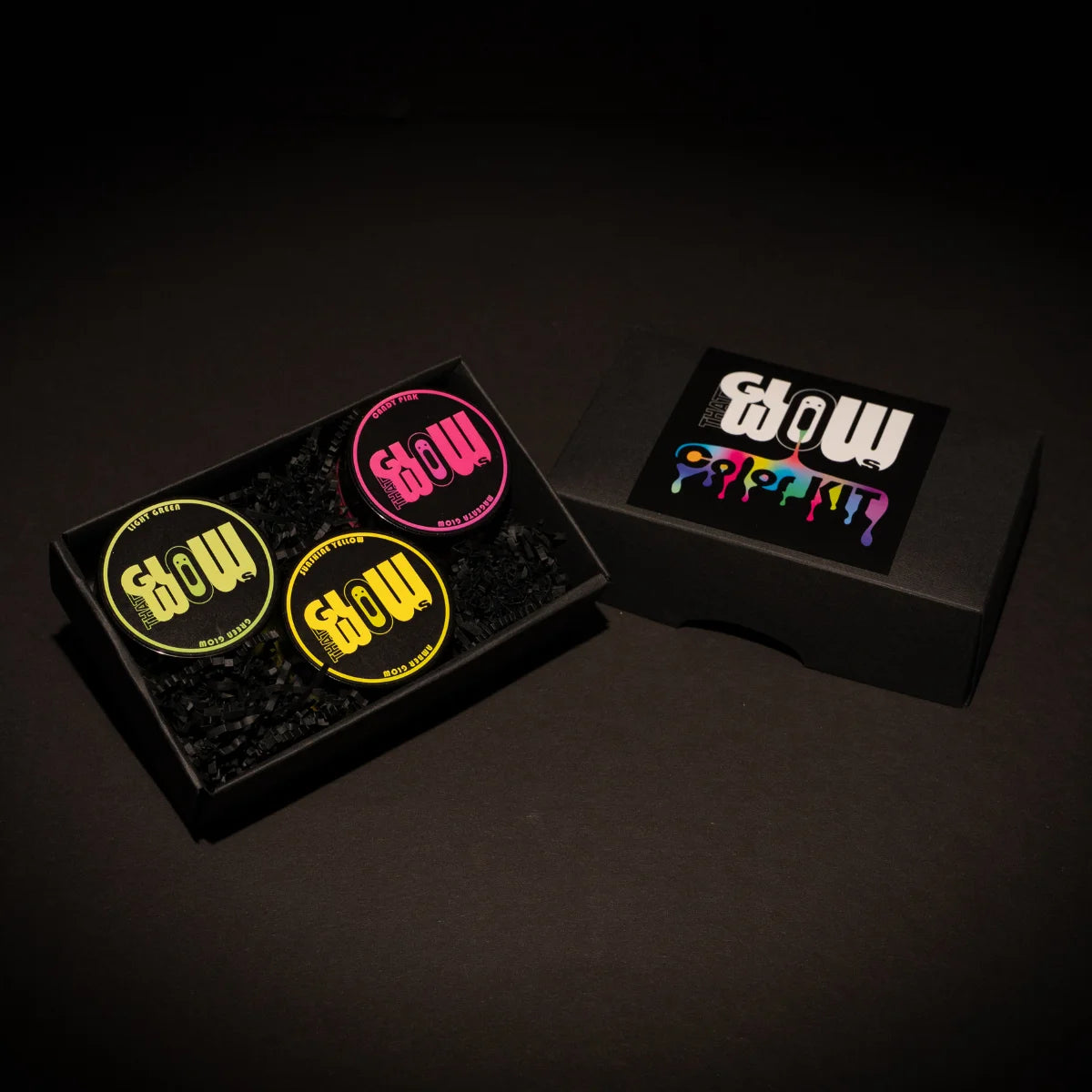 Overhead view of a premium 3-color neon acrylic glow paint kit in a sleek black tray—featuring vibrant yellow, hot pink, and lime green jars for long-lasting, best-in-class luminescence
