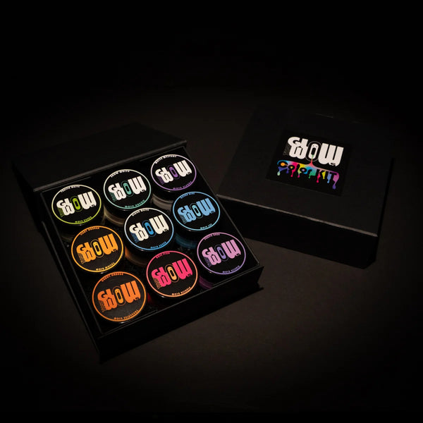 Overhead view of a 9-color neon acrylic paint kit in a sleek black tray, ready for glow-in-the-dark art projects