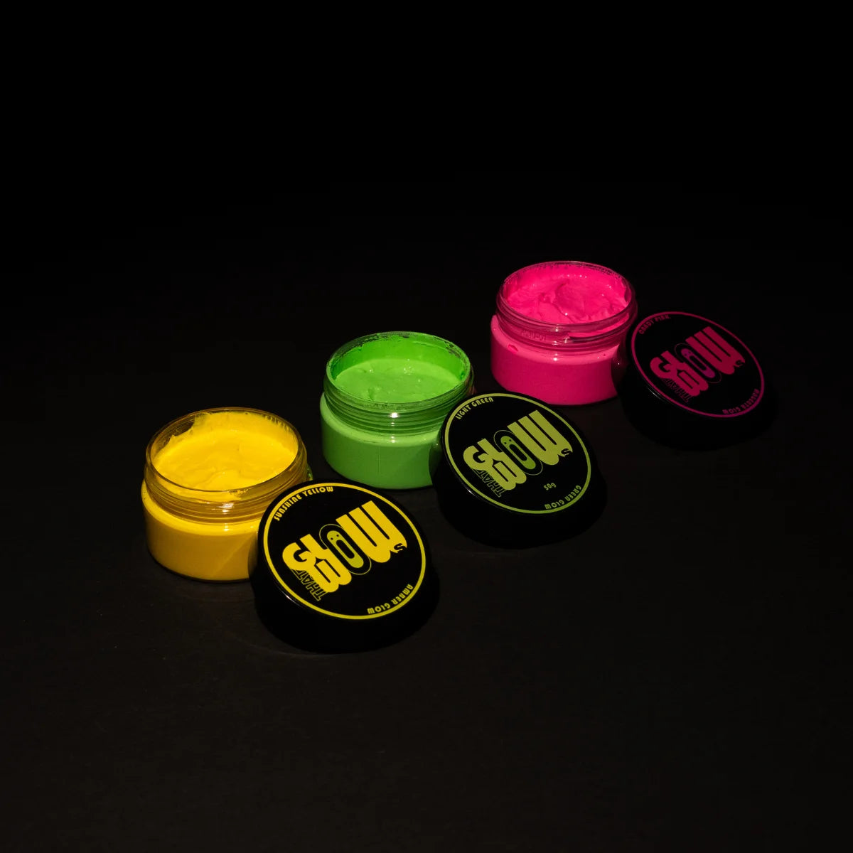 Top-down spread of three open phosphorescent paint jars—electric lime green, neon yellow, and vivid fuchsia—perfect for resin, clay, metal, and outdoor mural projects