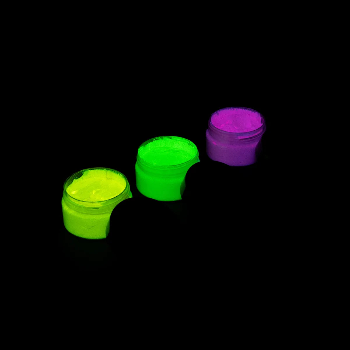 Charged strontium aluminate glow paint in three jars (lime green, yellow, pink) arranged neatly—delivering the brightest, long-lasting glow for canvas, fabric, and epoxy resin décor.